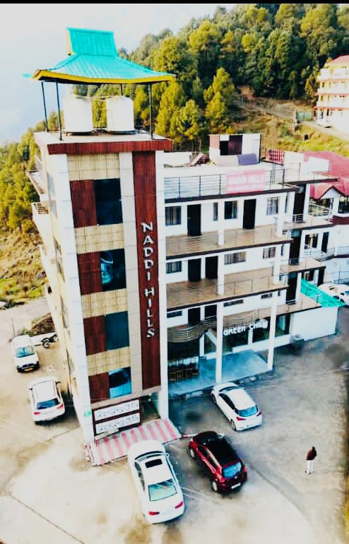 Hotel Naddi Hills facade at dusk, warm light in every window